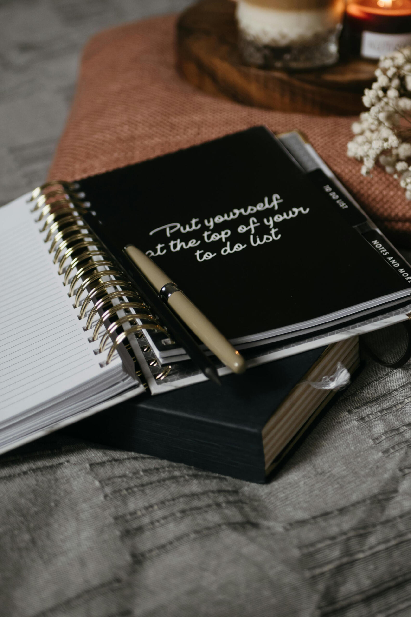 A journal with the quote ‘Put yourself at the top of your to-do list’, surrounded by soft textures and calm tones — inviting a moment of self-reflection.