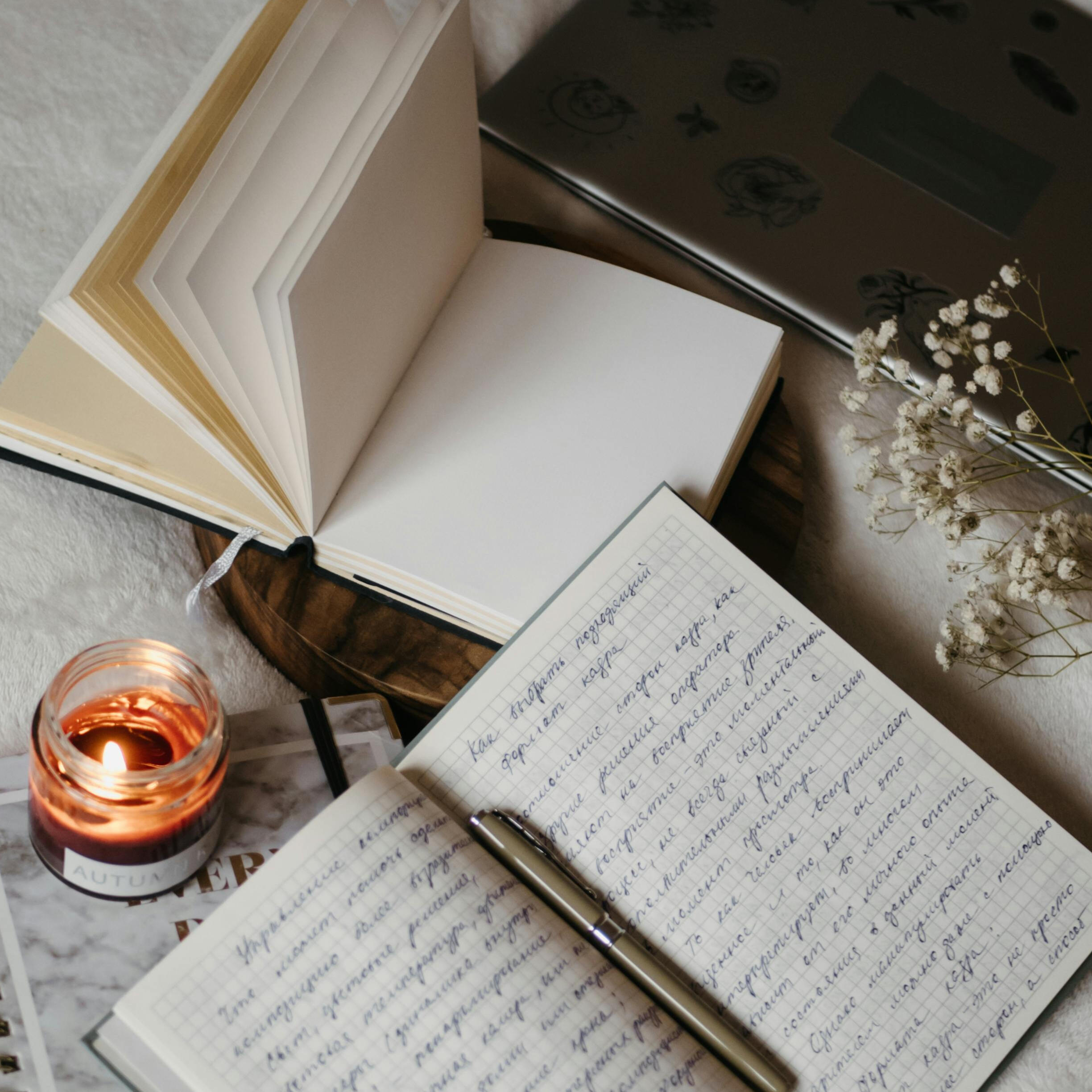 Journaling with candle and notebook on cozy blanket A cozy flatlay with an open journal, pen, candle, and soft textures — a safe space to reflect and write freely.